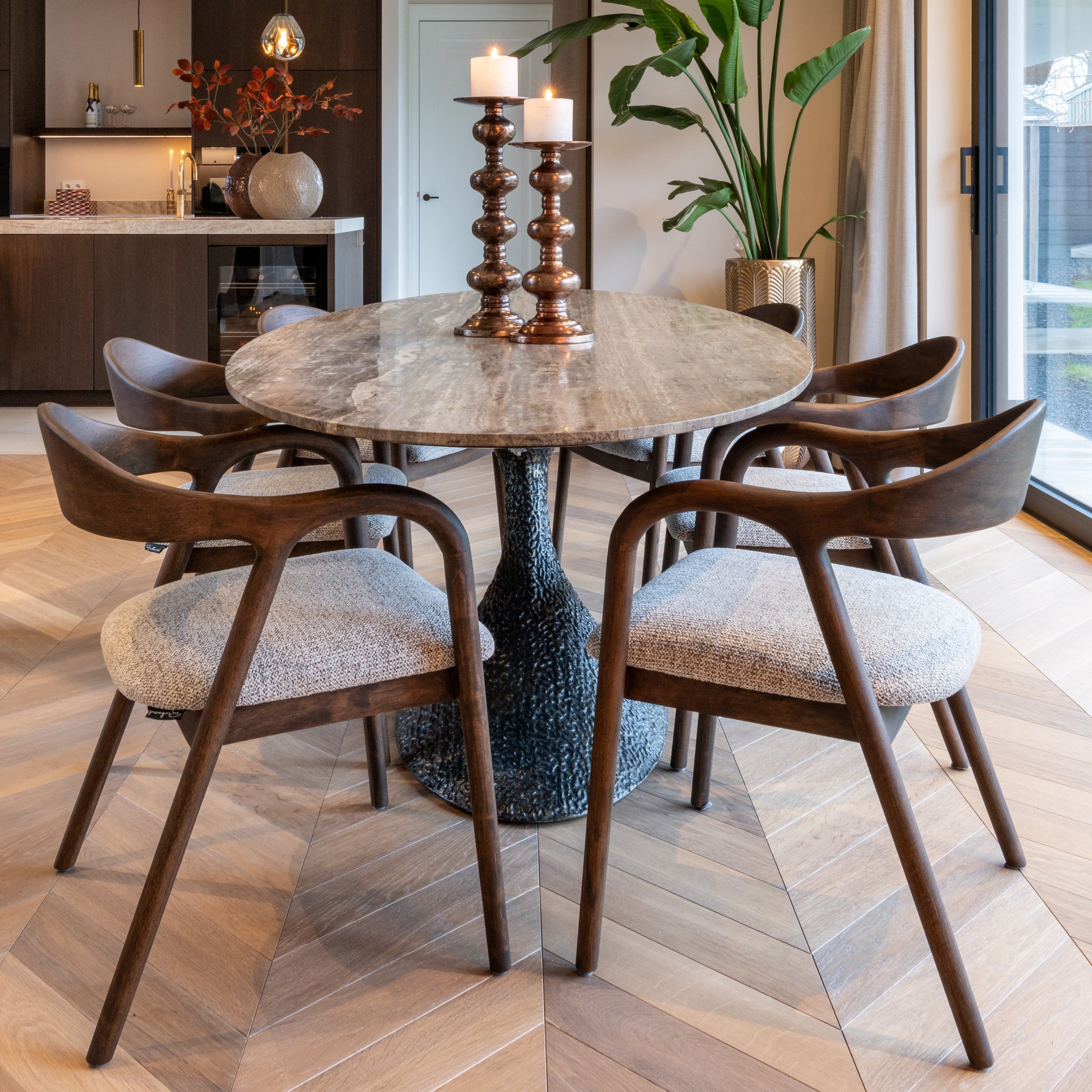 Dining area with marble table and wooden chairs in a modern kitchen.