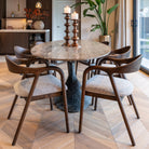 Dining area with marble table and wooden chairs in a modern kitchen.